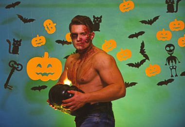 Yüzünde ve göğsünde kan olan adam kaslarını gösteriyor..