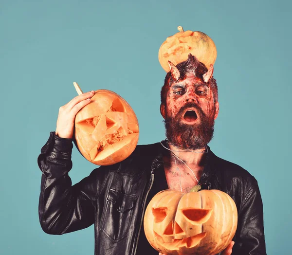 Demon with horns and proud face holds carved jack lanterns — Stock Photo, Image