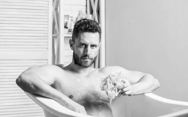 Hombre lavar el cuerpo muscular con esponja de espuma. Macho atractivo chico desnudo. Hombre sexy en el baño. Lavar la espuma con agua con cuidado. Concepto de sexo y relajación. Macho desnudo en la bañera. Realidad sexy —  Fotos de Stock