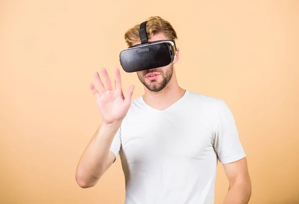 Explore cyber space. Man hipster with virtual reality headset on peach background. Entertainment and education. Virtual communication. Virtual simulation. VR for gaming. Man play game in VR glasses — Stock Photo, Image