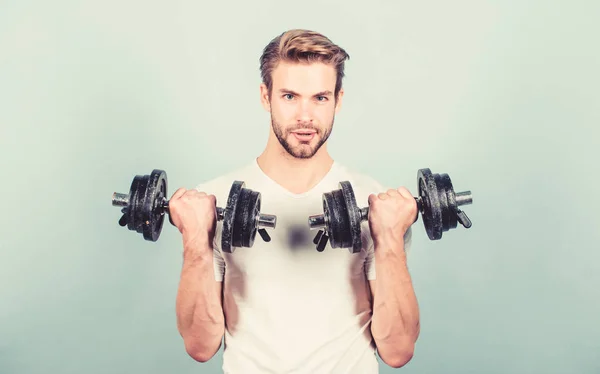 ダンベルで運動する筋肉の男。スポーツマンは強い筋肉を訓練します。スポーツ用品。フィットネスとボディービルのスポーツ.スポーツライフスタイル。スポーツのモチベーション。ハンサムな男のワークアウト。ジムでのエクササイズ — ストック写真