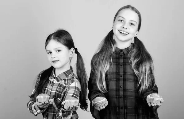 Comida casera. Alimentación saludable y calorías. Deliciosas magdalenas. Chicas lindos niños comiendo magdalenas o magdalenas. Dulce postre. Receta culinaria. Sabroso bocadillo. Habilidad para cocinar. Hermanas sostienen magdalenas horneadas —  Fotos de Stock