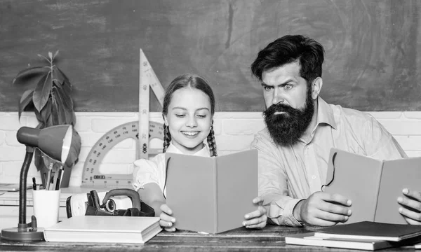 Concentrated on studying. small girl child with bearded teacher man in classroom. daughter study with father. Teachers day. back to school. Private teaching. knowledge. Home schooling. private lesson