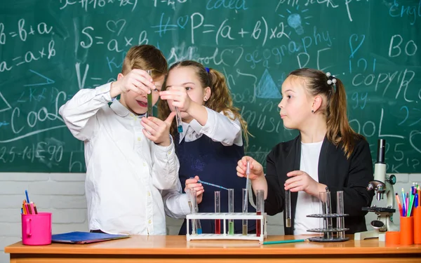 Reagenzgläser mit bunten Substanzen. Mädchen und Jungen experimentieren in der Schule mit Flüssigkeiten. Prüfergebnis. Chemieunterricht in der Schule. Schullabor. Schüler untersuchen chemische Flüssigkeiten — Stockfoto