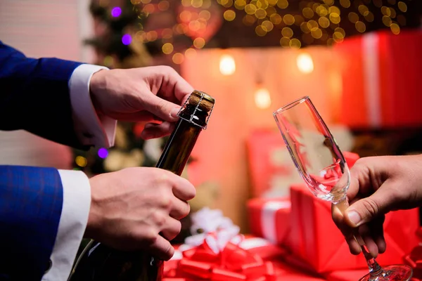 Nieuwjaar Countdown. Handen openen Champagne fles en houden glazen kerstversiering achtergrond. Last Minute voor Nieuwjaar. Drink Champagne of mousserende wijn. Vier Nieuwjaar met Champagne — Stockfoto