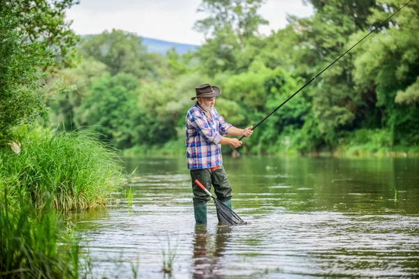 Get hooked. fisherman with fishing rod. summer weekend. Big game fishing. retired bearded fisher. Trout bait. hobby and sport activity. pothunter. mature man fly fishing. man catching fish — Stock Photo, Image