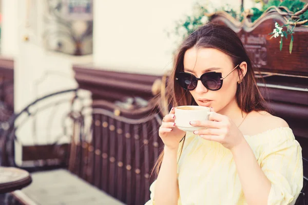 Mädchen genießen Morgenkaffee. Frau mit Sonnenbrille trinkt Kaffee im Freien. Mädchen entspannen im Café Cappuccino Tasse. Koffeindosis. Kaffee für einen energiegeladenen erfolgreichen Tag. Warten auf das Datum. Frühstückszeit im Café — Stockfoto