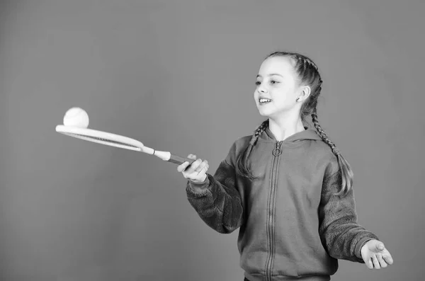 Enfocado en la pelota. Ocio activo y hobby. Tenis deporte y entretenimiento. Niña adorable niña jugar tenis. Practicar las habilidades de tenis y divertirse. raqueta de tenis atleta niño sobre fondo azul —  Fotos de Stock