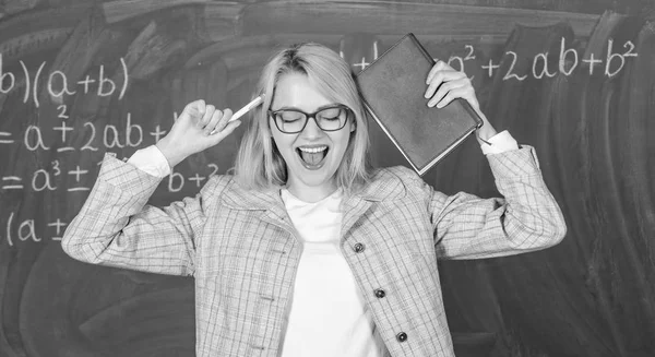 Overwork and lack of support driving teacher out of profession. School toxic routine. Teacher stress and burnout. Teacher woman with book chalkboard background. Why teacher quit off sick with stress