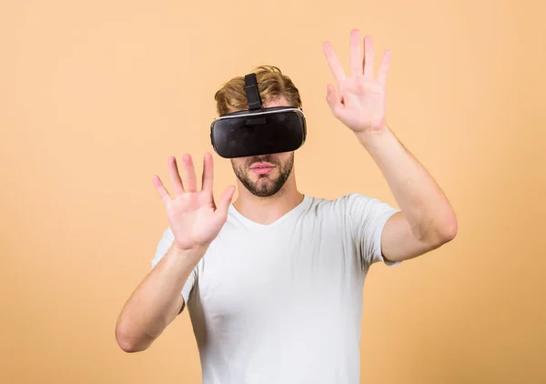 Virtuální simulace. VR pro hraní her. Muž hraje hru ve VR. Prozkoumejte kyberprostor. Muž s virtuálními reality s mikrofonem na broskvové pozadí. Zábava a vzdělání. Virtuální komunikace — Stock fotografie