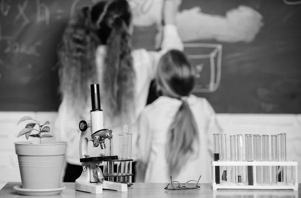 Biology concept. Microscope and test tubes on table in classroom. Kid near school chalkboard background defocused. School biology lesson. Kid study biology with equipment in school. Knowledge day — Stock Photo, Image