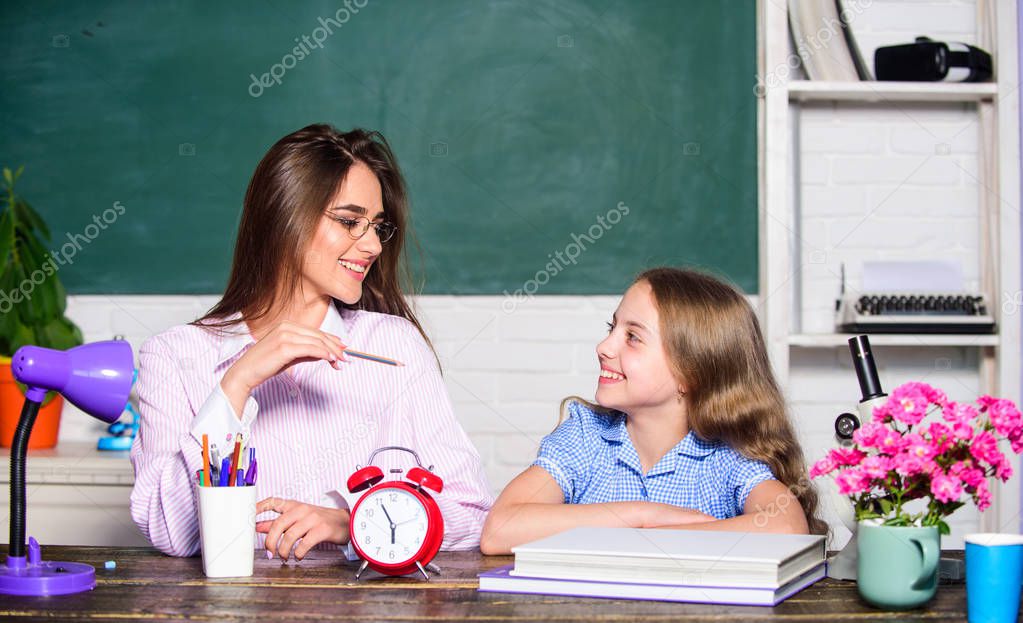 School education. Studying together. Help with homework. Homework project. Sister helping with learning. Teacher kind lady with pupil. Doing homework with mom. Little girl and woman sit at desk