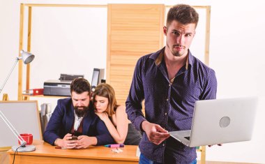 İş için en iyi dizüstü bilgisayar. İşadamı dizüstü bilgisayar kullanırken akıllı telefon mobil teknolojisini kullanıyor. Dizüstü bilgisayarda proje yapan kendinden emin yönetici. Ofiste dizüstü bilgisayar ile genç çalışan ayakta