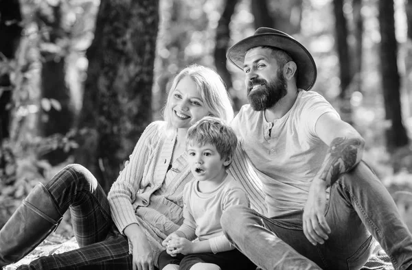 Gelukkige zoon met ouders ontspannen in herfst bos. Zonnig weer. Gezonde voeding. Moeder, vader van cowboy houden hun kindje van de jongen. Lente stemming. Gelukkig familiedag. Familie picknick. Uitdrukkelijke positiviteit — Stockfoto