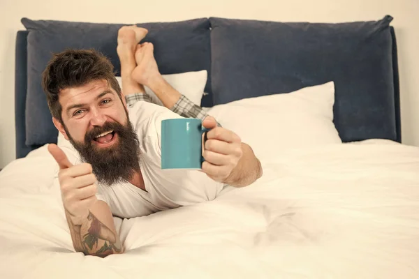 J'aime le café frais. heureux homme barbu hipster boire café du matin. homme endormi brutal dans la chambre. mâle mature avec barbe en pyjama sur le lit. endormi et réveillé. énergie et fatigue. Café frais — Photo