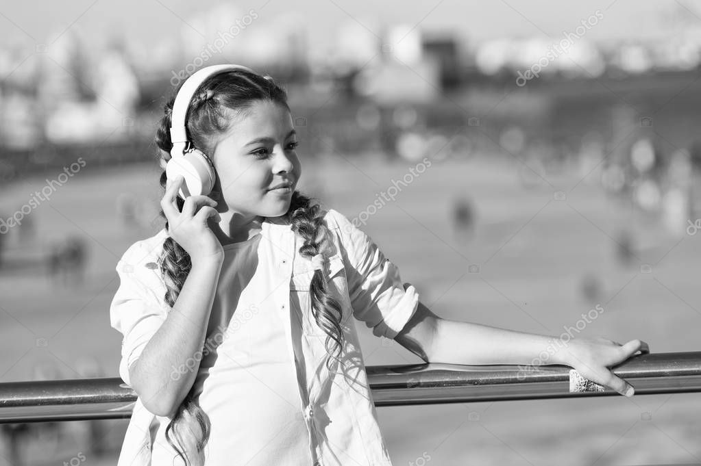 City guide and audio tour. Girl little tourist kid explore city using audio guide application. Free style of travelling. Exciting journeys through cities and museums. Audio tour headphones gadget