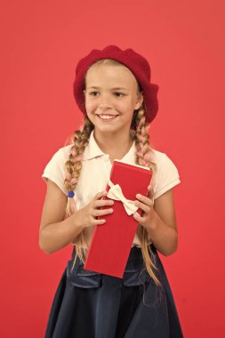 Çocuk küçük kız okul üniforması ve bere hediye kutusu tutun. Çocuk/açma hediye hakkında heyecanlı. Küçük sevimli kız alınan tatil hediye. Mutluluk yaymak. Çocuklar için en iyi hediye. Mutlu çocukluk anları