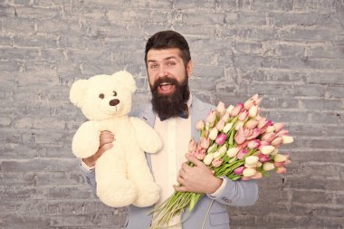 Üzgünüm. Kadınlar günü. Seni çok seviyorum. 8 Mart. Bahar hediyesi. Çiçekleri olan sakallı adam hipster. Lale buketi ve ayılı sakallı adam. Aşk randevusu. uluslararası tatil. Aşk ve romantizm