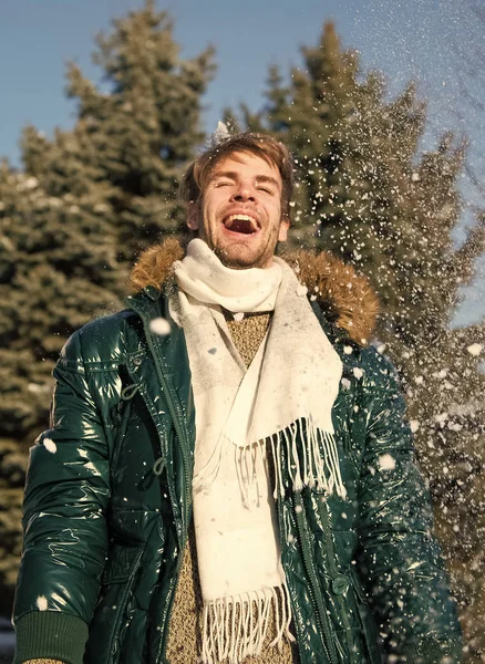 Hipster marche journée d'hiver enneigée. Flocons de neige dans l'air par une belle journée d'hiver. Concept de mode d'hiver. Homme unshaven porter une veste chaude avec fourrure et écharpe fond nature enneigée. Guy profiter ensoleillé journée d'hiver — Photo