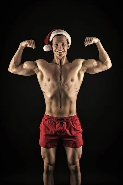 Noel Baba şapkası seksi kaslı adam. Yeni yıl partisi. Noel Baba adam. Mutlu kış tatili. Kırmızı. Noel için hediye. Noel alışveriş. Fitness için adanmış. Mutlu Noeller ve mutlu yeni yıl — Stok fotoğraf