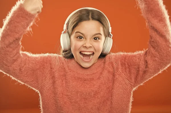 La música es su alma. Niña linda niña usar auriculares escuchar música. Niño escuchar música fondo naranja. Música recomendada basada en su interés inicial. Aplicación de radio para su dispositivo móvil — Foto de Stock