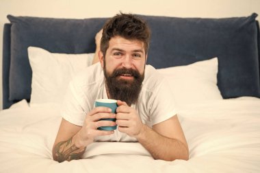 Rahatla ve dinlen. Enerji dolu. Kahve vücudu etkiler. Adam yakışıklı hipster kahve fincanı ile yatakta rahatlatıcı. Sakallı hipster sabah kahvesi tadını çıkarın. Sabah iyi kahve ile çok daha iyi olur