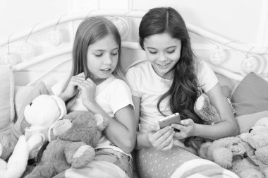 Noel babaya manifatura. Cep telefonu ile mutlu küçük çocuklar. Küçük kızlar yatakta smartphone kullanın. Noel ve yeni yıl hediyesi telefonla sipariş. Mutlu Noeller ve mutlu yeni yıl tebrik