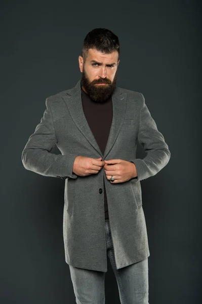 Choosing trendy outfit perfect for his style. Brutal hipster wear fashionable mustache and beard hair style. Bearded man buttoning casual style jacket on grey background. There is style for every man — Stock Photo, Image