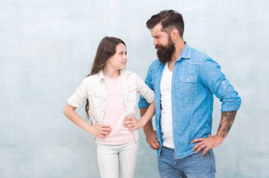 Kız kuralları. Yaramaz kız kötü davranıyor. Gri arka planda babası olan küçük kız çocuk. Sevimli küçük kız ve sakallı adam kalça ellerini koyarak