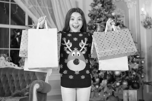 Маленькая девочка любит рождественский подарок. Рождество. Наслаждайся праздником. С Новым годом. маленькая счастливая девочка на Рождество. Девушка с сумками. Утром перед Рождеством. Новый год. зима — стоковое фото