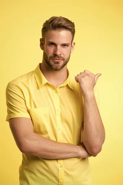 La solución está aquí. Joven guapo manteniendo la mano en la barbilla mientras está de pie fondo amarillo. Una pregunta difícil. Dificultades morales. Escúchate. Pregunta sin respuesta. Señalar con el dedo — Foto de Stock