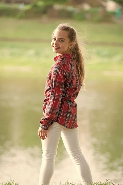 Amazing kid. Little kid wearing fashion summer outfit. Small cute kid with beauty look on natural landscape. Adorable kid with long blond hair in casual plaid style — Stock Photo, Image