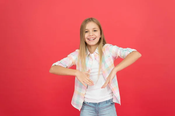 Hip en stijlvol. lachende blonde jongen. kind meisje met lange blonde haren. casual stijl. Childrens dag. modieuze kleine meisje. Kid mode. stijlvolle schoonheid. kleine meisje rode achtergrond. gelukkige kindertijd — Stockfoto