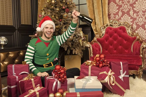 Happy holidays en een welvarende 2019. Man in santa hat greep nieuwe jaar presenteert. Guy viert Nieuwjaar thuis. Gelukkig man met Nieuwjaar geschenkdozen. Prettige kerstdagen en gelukkig Nieuwjaar — Stockfoto