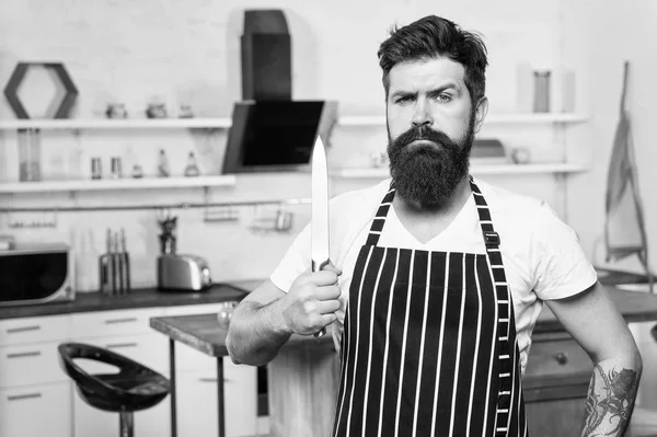 Keuken apparatuur. culinaire activiteiten. smakelijke gerechten. serieuze en zelfverzekerde chef-kok in restaurant. bebaarde man hipster in keuken met mes. brutale man in Cook schort. volwassen man met baard koken — Stockfoto