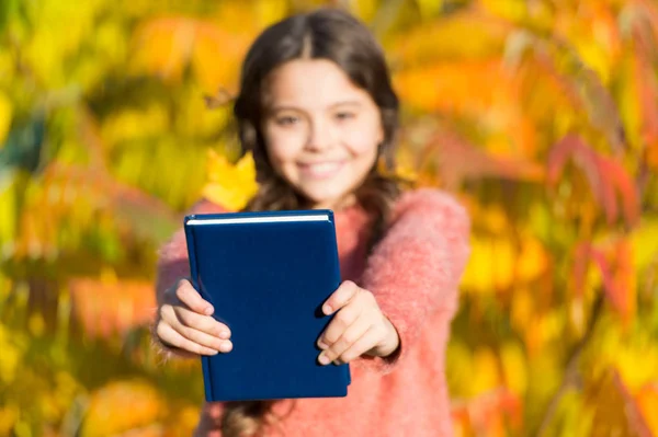 Concepto de literatura otoñal. Niño pequeño disfrutar de la lectura de fondo follaje otoño. A los niños pequeños les gusta aprender en el parque de otoño. Estudio infantil con libro. Sigue estudiando. Niña leer libro en el día de otoño — Foto de Stock