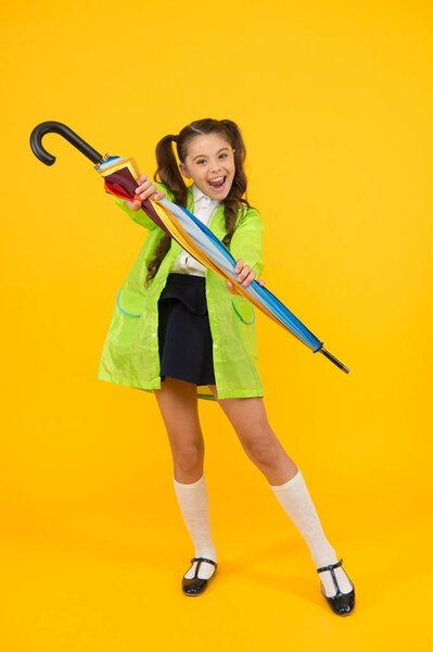 In case it will rain. Happy small schoolchild in raincoat holding umbrella against rain. Cute little girl with fashion accessory keeping her dry in wet rain weather. Its great for rain shower.