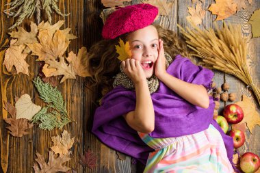 Çocuk kız parlak yumuşak örme şapka sonbahar tadını çıkarın. Sonbahar moda şapka aksesuarı. Örme şapka kız sevimli çocuk ahşap arka plan düşmüş akçaağaç üst görünümü bırakır yatıyordu. Moda şapka trendi sonbahar sezonu