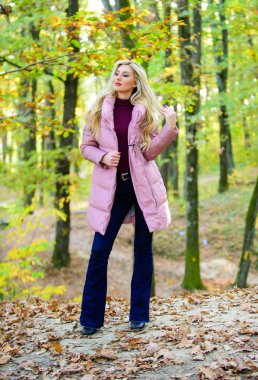Outfit prove puffer coat can look stylish. Jackets everyone should have. Girl fashionable blonde walk in park. Best puffer coats to buy. How to rock puffer jacket like star. Fall fashion concept