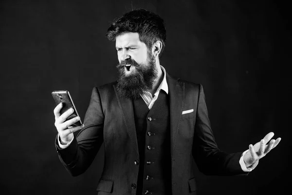 bad feedback from client. angry bearded man with smartphone. brutal caucasian hipster. businessman in suit. online and agile. Mature hipster with beard speak on phone. stressed man shouting