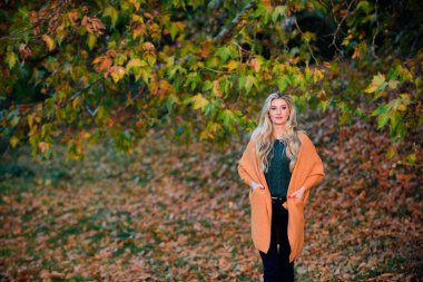 Kadın gün batımı ışık yürümek. Rahat bir kıyafet. Kız sevimli sarışın sıcak ve rahat kıyafeti sonbahar doğa arka plan defocused poz. Geç sonbahar için rahat rahat kıyafetler. Hafta sonu için rahat kıyafet fikirleri