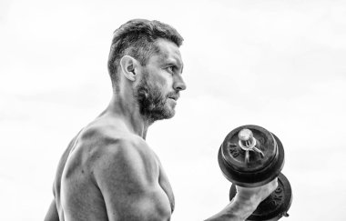 Büyüklüğün bedeli sorumluluktur. Aptal egzersiz salonu. Dambılla egzersiz yapan kaslı bir adam. Güçlü gövdeli bir sporcu. Spor aletleri. Fitness ve vücut geliştirme sporu. Jimnastik konsepti