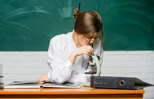 研究成果の分析化学や生物学の研究室の研究をしているかわいい女性。スクールラボで顕微鏡を用いて研究に取り組むスマートな学生。科学・研究支援 — ストック写真
