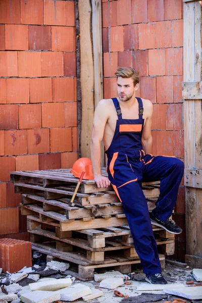 Trabajador de confianza. reparador profesional accesorios de sombrero duro. hombre constructor en ropa de trabajo. edificio y construcción. ingeniero con herramienta. arquitecto reparar y arreglar. trabajador relajarse paleta de madera —  Fotos de Stock