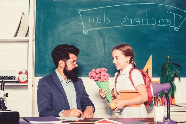 flower present for best teacher. knowledge day is 1 september. small school girl kid with flower. back to school. Happy teachers day. teachers day. Daugghter and father with flowers. happiness