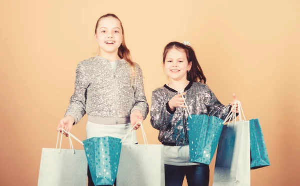 Gelukkige kinderen. Kleine meisje zusters online winkelen. Verkoop en kortingen. Sisterhood en familie. besparingen op aankopen. Kid mode. Shop Assistant met pakket. Kleine meisjes met boodschappentassen — Stockfoto