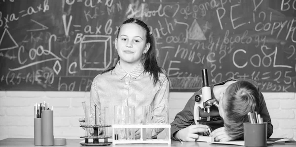 Дівчинка і хлопчик спілкуються під час проведення шкільного експерименту. Діти навчаються разом у класі. Шкільна освіта. Хімічний аналіз. Діти вивчають хімію. Урок хімії школи. Шкільна лабораторія — стокове фото