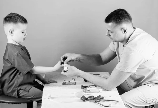 Servicio médico. Hombre doctor sentarse mesa herramientas médicas examinando niño pequeño paciente. Concepto de pediatra. Salud. Cuidado de niños. El pediatra cuidadoso comprueba la salud del niño. Examen médico — Foto de Stock