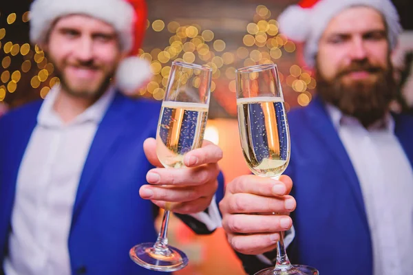 Os empresários bebem champanhe na festa. Os colegas celebram o Ano Novo. Homens ternos formais e chapéus de Papai Noel segurar copos de champanhe. Um conceito de saúde. Festa corporativa de Ano Novo. Festa com champanhe — Fotografia de Stock