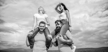 Sadece biraz eğleniyoruz. Sevgi dolu çiftler açık havada eğlenceli aktiviteler yapıyor. Sevgi dolu çiftler birlikte eğlenirler. Aşık oyuncu çiftler bulutlu gökyüzünde gülümsüyor. Mutlu erkekler kız arkadaşlarını sırtlı